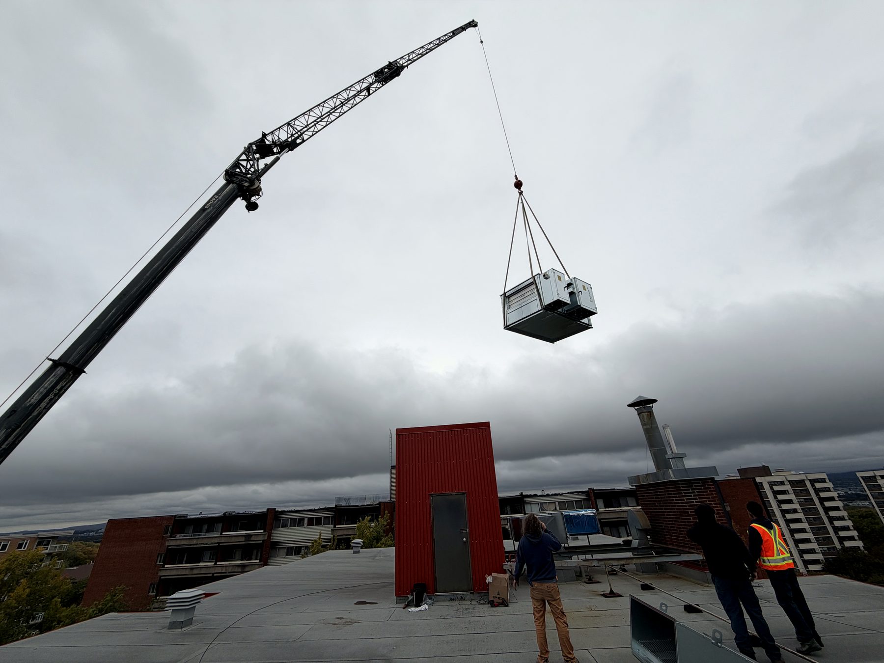 Unité d'entrée d'air frais (air make-up) neuve levée à la grue jusqu'au toit, installation par Services Techniques NRJ