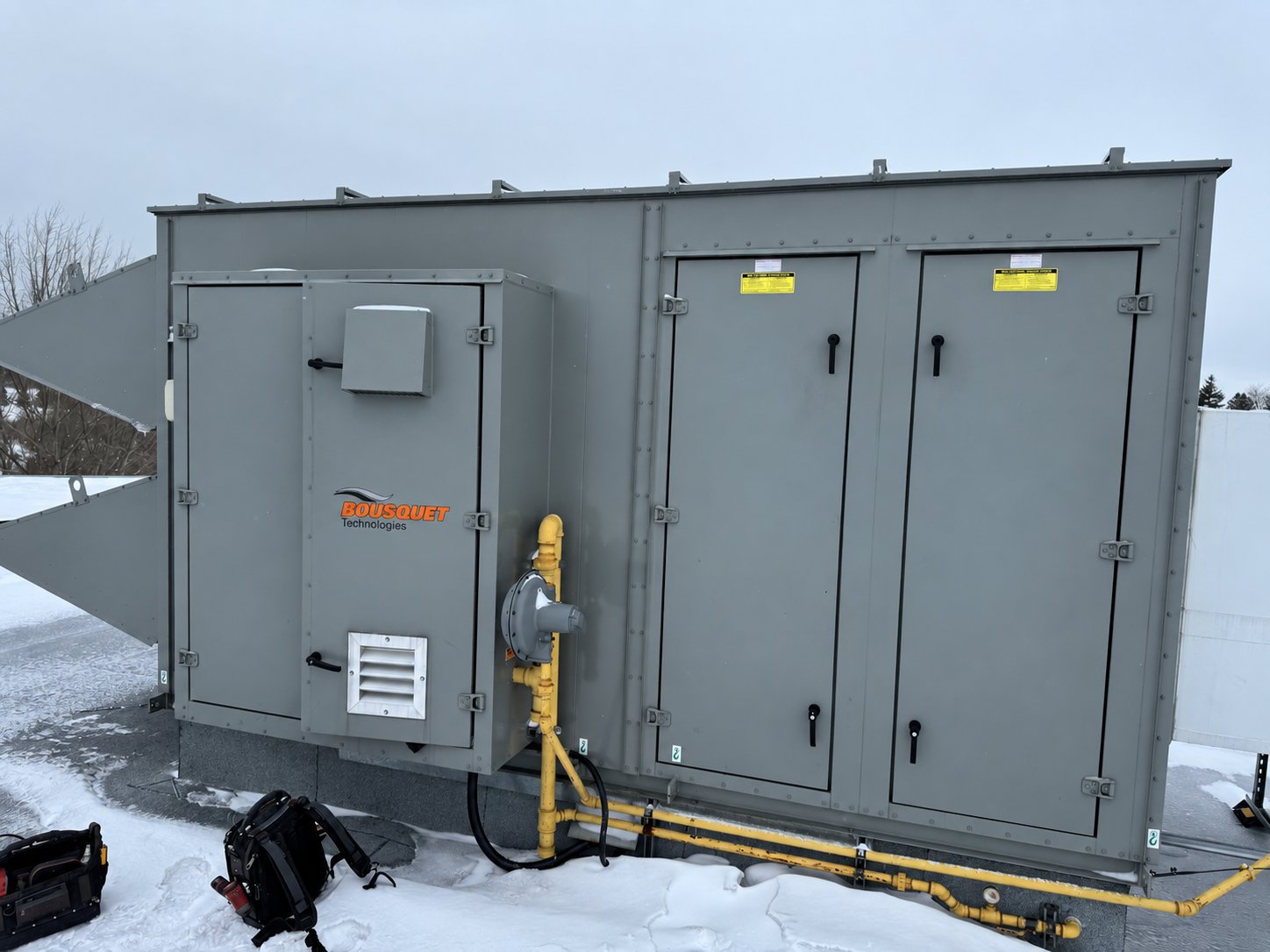 Unité d'air make-up Bousquet sur un toit en hiver, avec son train de gaz jaune